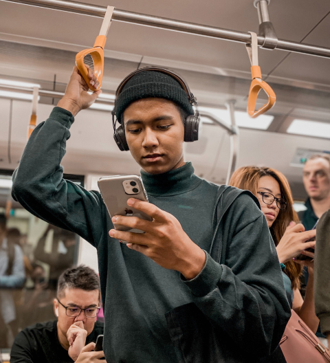 man looking at his phone while on the subway