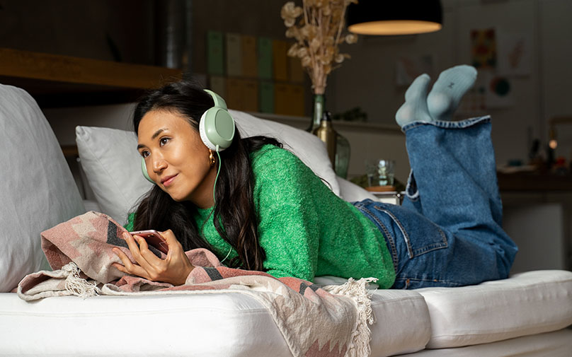 Top 5 Financial Podcasts Women Listening to a Podcast on Couch