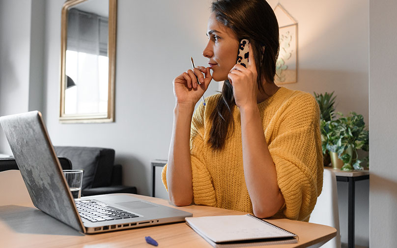 Debt Settlement Women on phone in front of laptop