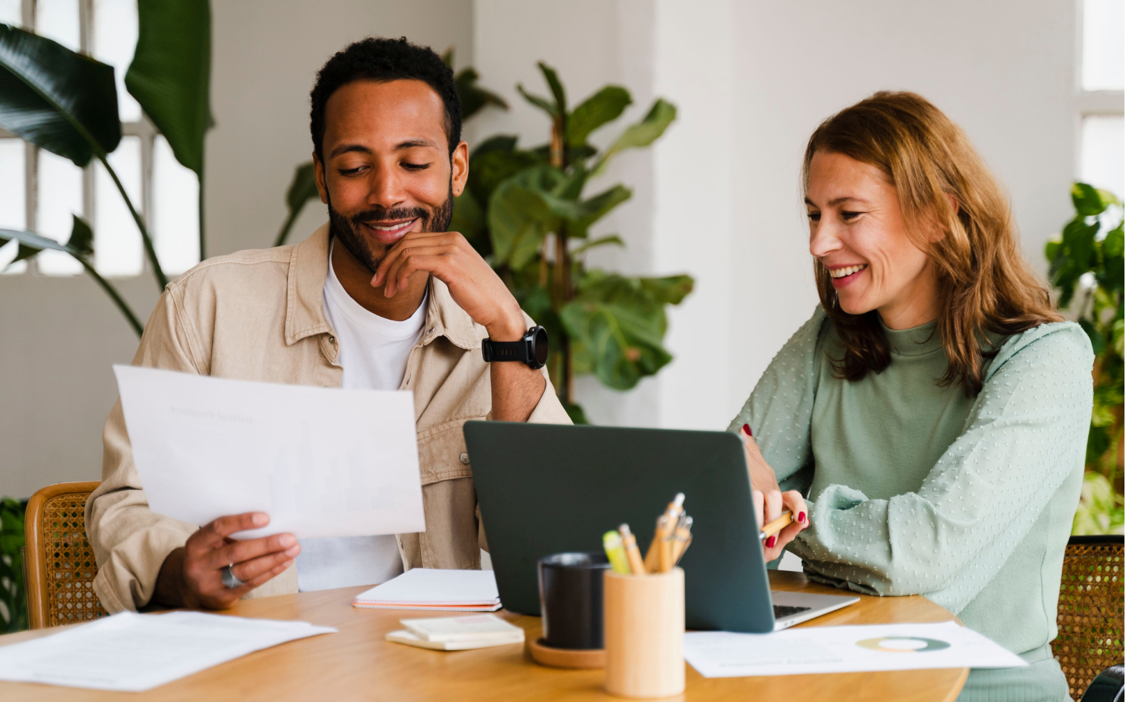 man and woman looking at bills at kitchen table